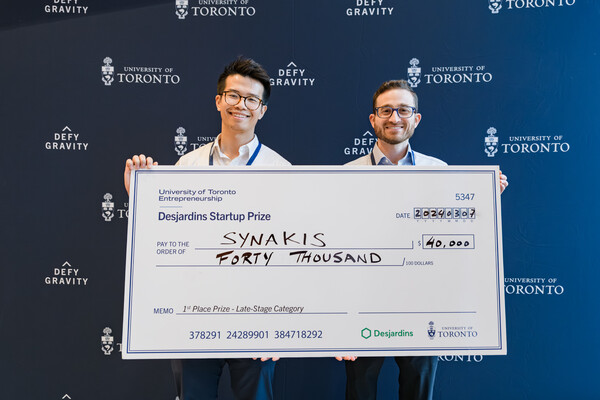 Two members of the Synakis team holding up a large cheque for $40,000
